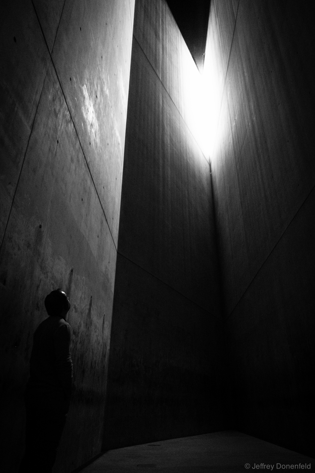 Jewish Museum, Berlin. This is the Holocaust Tower. From Wikipedia: "The first axis ends at a long staircase that leads to the permanent exhibition. The second axis connects the Museum proper to the E.T.A. Hoffmann Garden, or The Garden of Exile, whose foundation is tilted. The Garden's oleaster grows out of reach, atop 49 tall pillars. The third axis leads from the Museum to the Holocaust Tower, a 79 foot (24 m) tall empty silo. The bare concrete Tower is neither heated nor cooled, and its only light comes from a small slit in its roof."